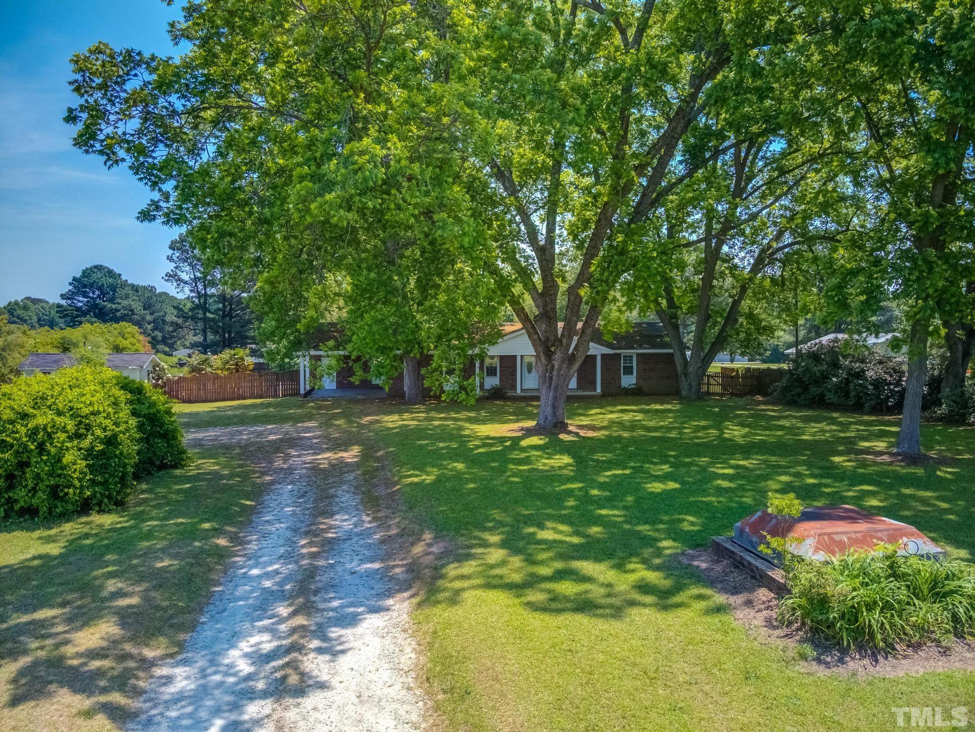 9101 Old Stage Road Raleigh, NC 27603 - Photo 46 of 60 a view of a backyard with table and chairs plants and large trees