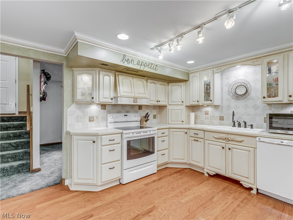3760 North Santom Road Stow, OH 44224 - Photo 23 of 33 Down the stairs is the updated eat-in kitchen with a beautifully accented tile backsplash, white cabinets, appliances, a pantry with pull-out drawers, and wood flooring.