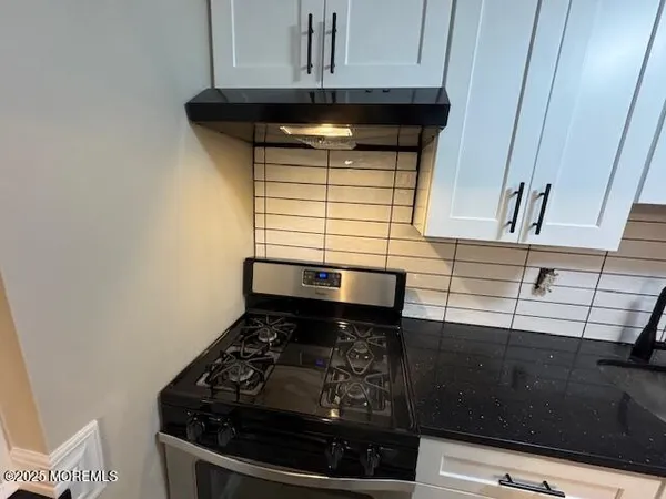 a stove top oven sitting inside of a kitchen