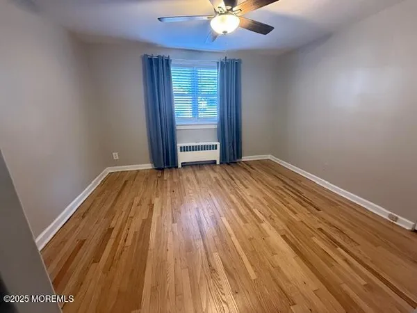 wooden floor in an empty room with a window