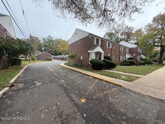 82 Manor Drive, Unit 803 Red Bank, NJ 07701 - Photo 36 of 39 a front view of a house with a yard and trees