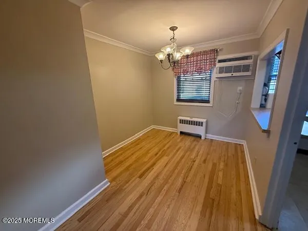 a view of a room with wooden floor and chandelier