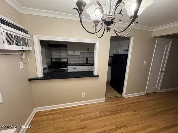 a view of a room with wooden floor and a ceiling fan