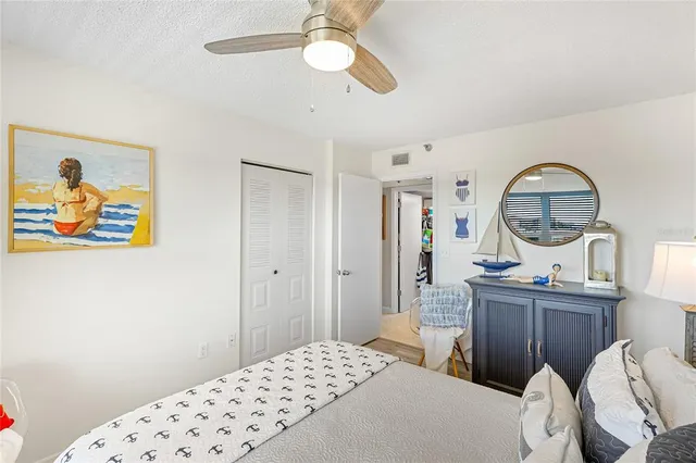 a bedroom with a bed a mirror on dresser and a chandelier