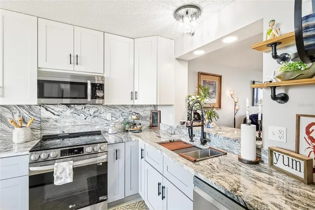 a kitchen with stainless steel appliances granite countertop a sink stove and cabinets