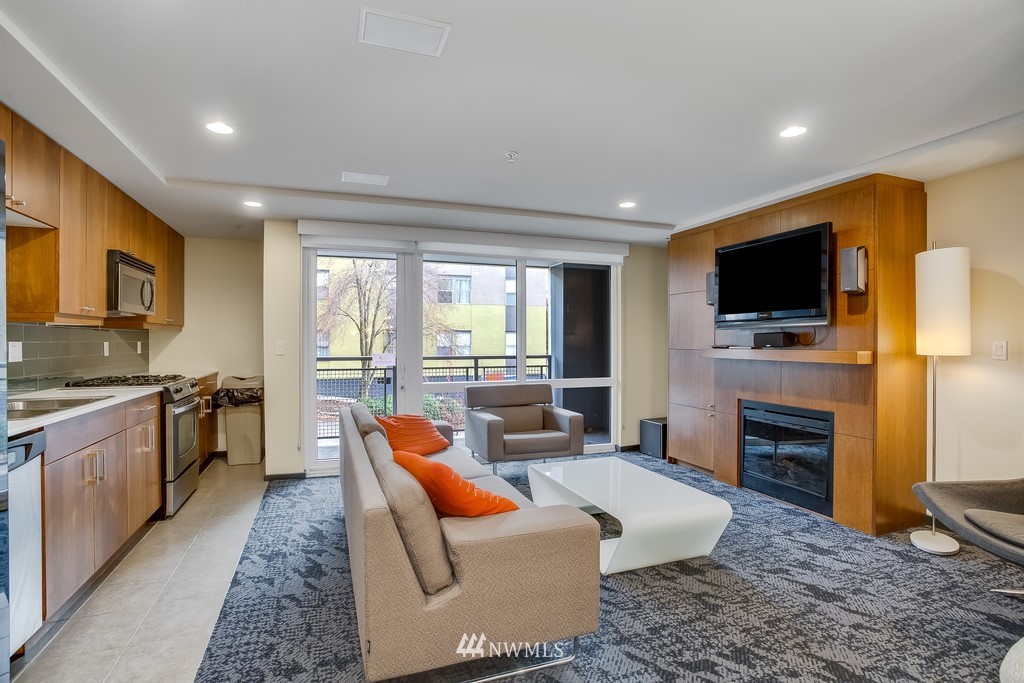76 Cedar Street, Unit 910 Seattle, WA 98121 - Photo 22 of 30 a living room with fireplace furniture and a flat screen tv
