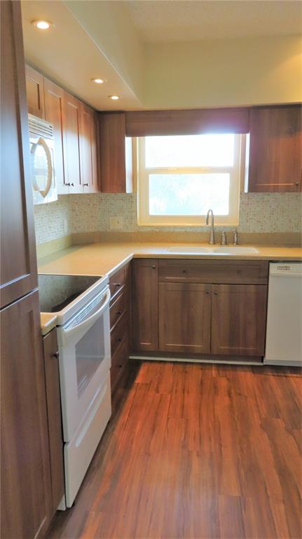 2295 Americus Boulevard East, Unit 29 Clearwater, FL 33763 - Photo 11 of 39 a kitchen with wooden cabinets and white appliances