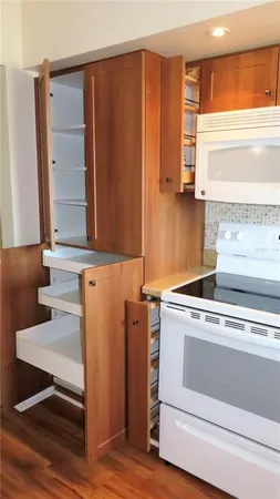 a kitchen with granite countertop white cabinets and white appliances
