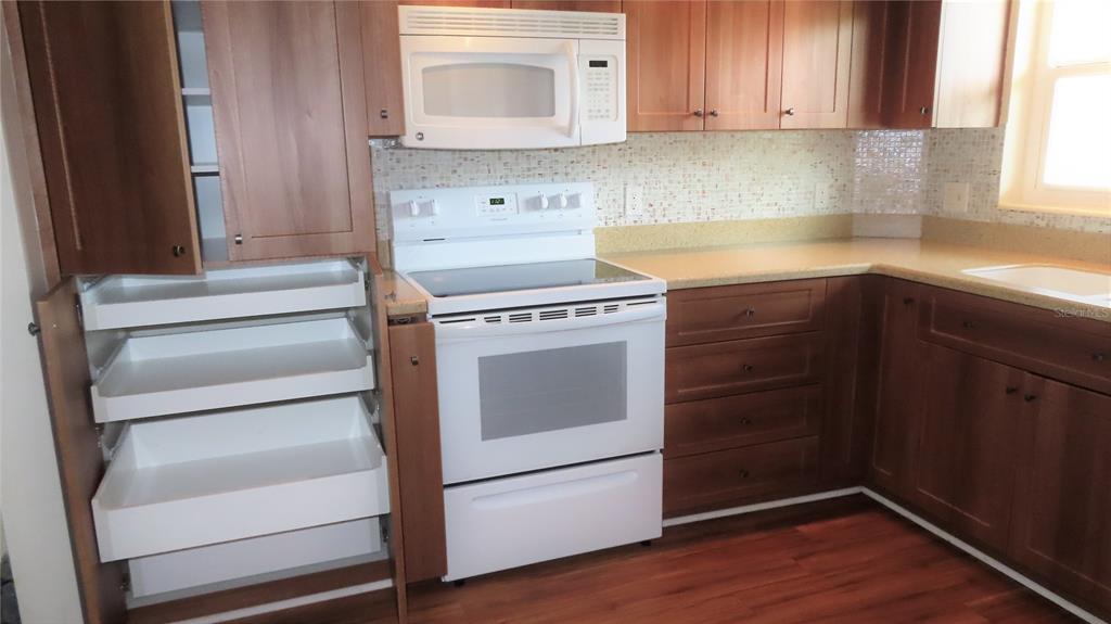 2295 Americus Boulevard East, Unit 29 Clearwater, FL 33763 - Photo 16 of 39 a kitchen with granite countertop white cabinets and white appliances