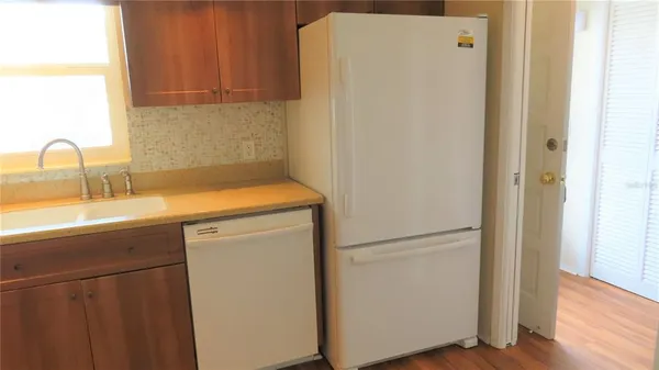 a kitchen with a refrigerator sink and cabinets
