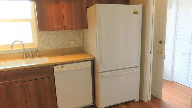 a kitchen with a refrigerator sink and cabinets