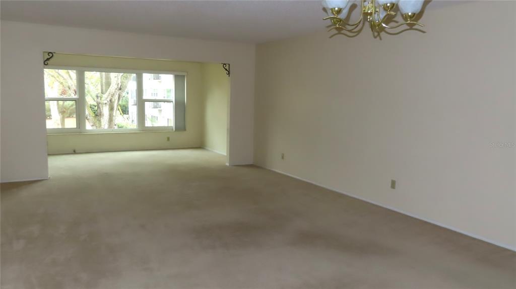 2295 Americus Boulevard East, Unit 29 Clearwater, FL 33763 - Photo 20 of 39 a view of a big room with windows and chandelier fan