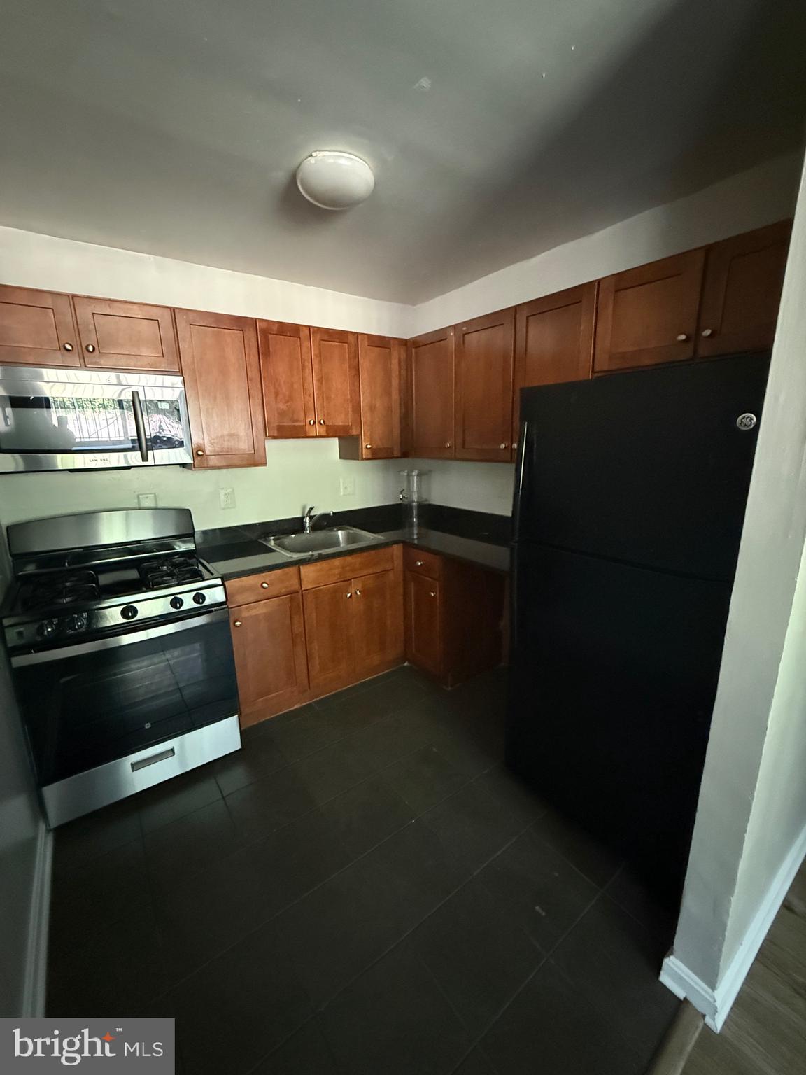 3105 Naylor Road Southeast, Unit 104 Washington, DC 20020 - Photo 8 of 12 a kitchen with stainless steel appliances a stove a sink and a refrigerator