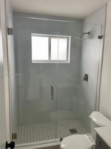 a bathroom with a toilet and a shower