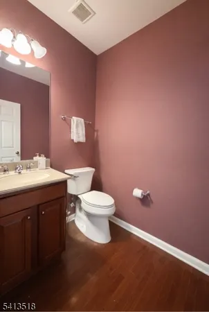 a bathroom with a toilet sink a mirror and vanity