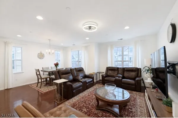 a living room with furniture a flat screen tv and a window