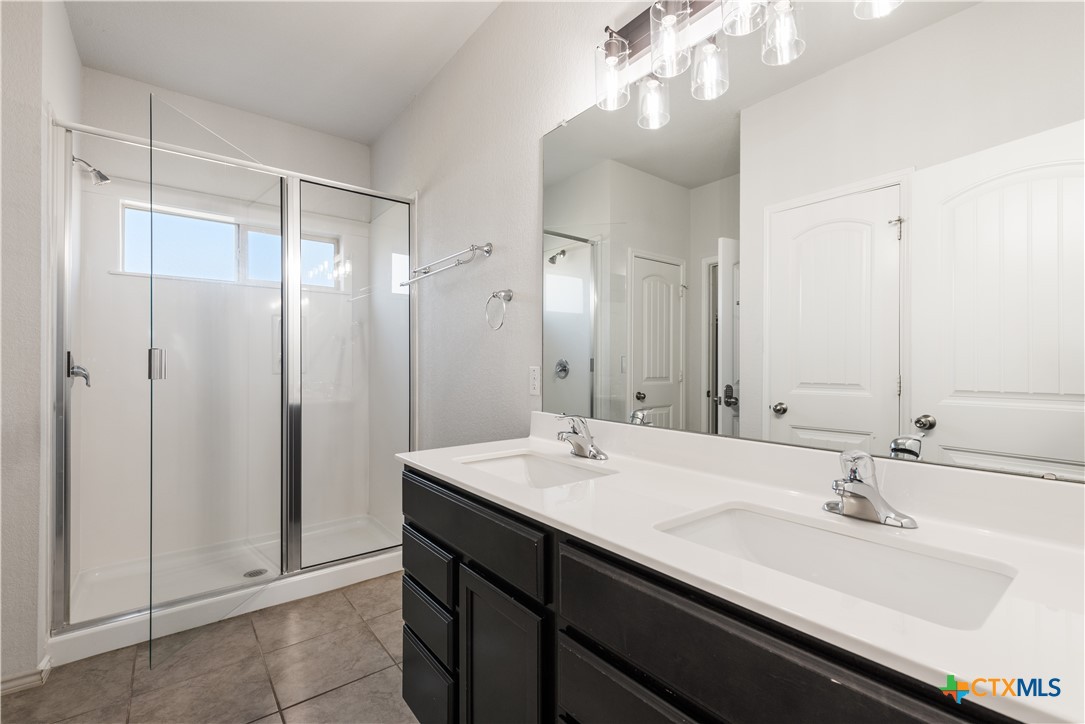 1129 Ibis Falls Loop Jarrell, TX 76537 - Photo 11 of 39 a bathroom with a double vanity sink mirror and shower