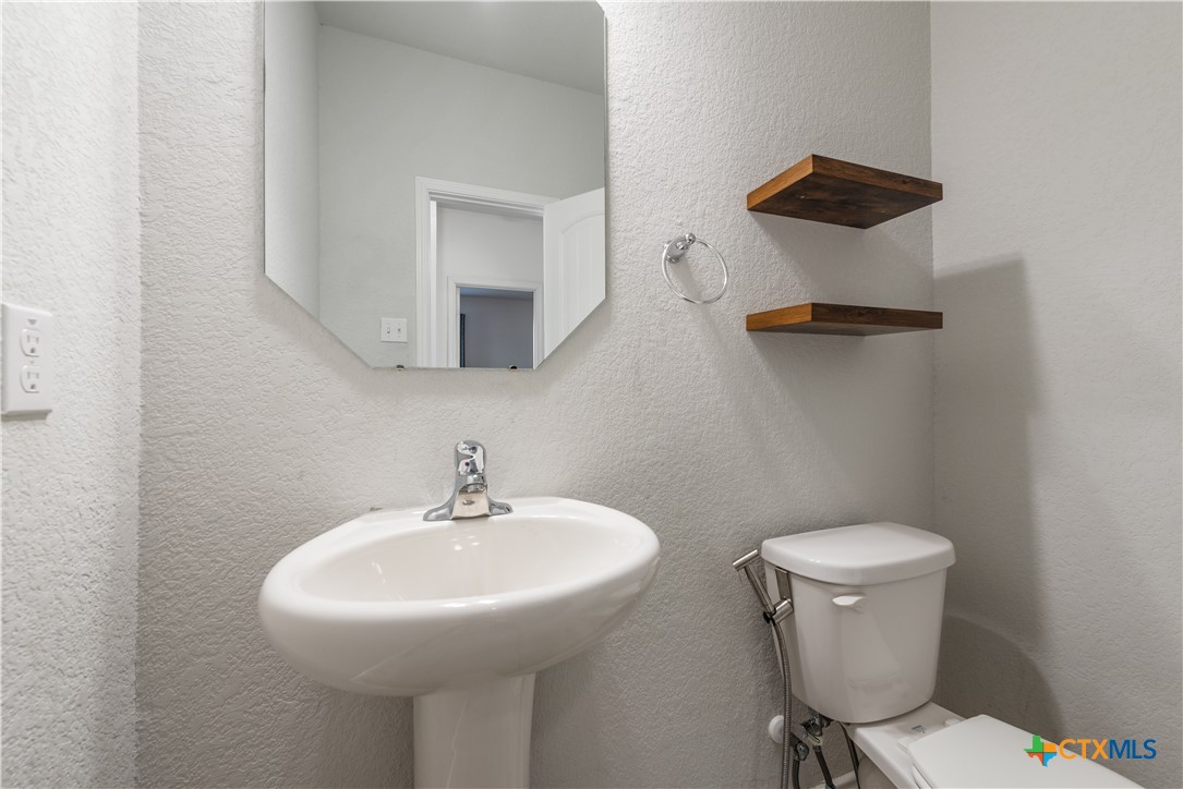 1129 Ibis Falls Loop Jarrell, TX 76537 - Photo 23 of 39 a bathroom with a sink a toilet and mirror