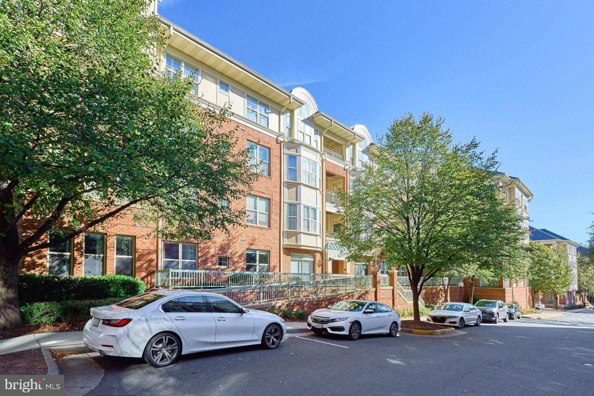 1851 Stratford Park Place, Unit 212 Reston, VA 20190 - Photo 4 of 39 a city street lined with parked cars and buildings