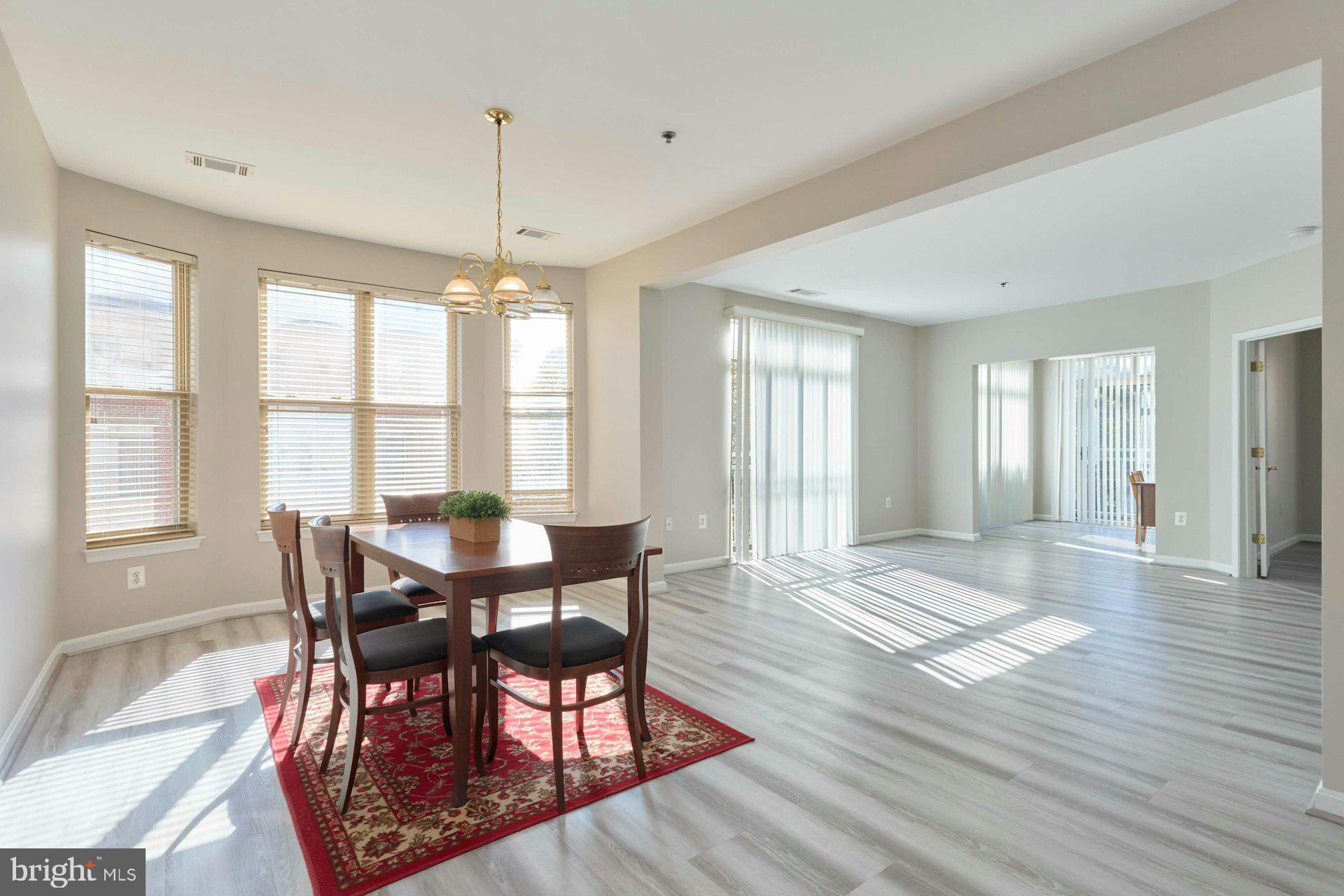 1851 Stratford Park Place, Unit 212 Reston, VA 20190 - Photo 5 of 40 a view of a dining room with furniture window and wooden floor