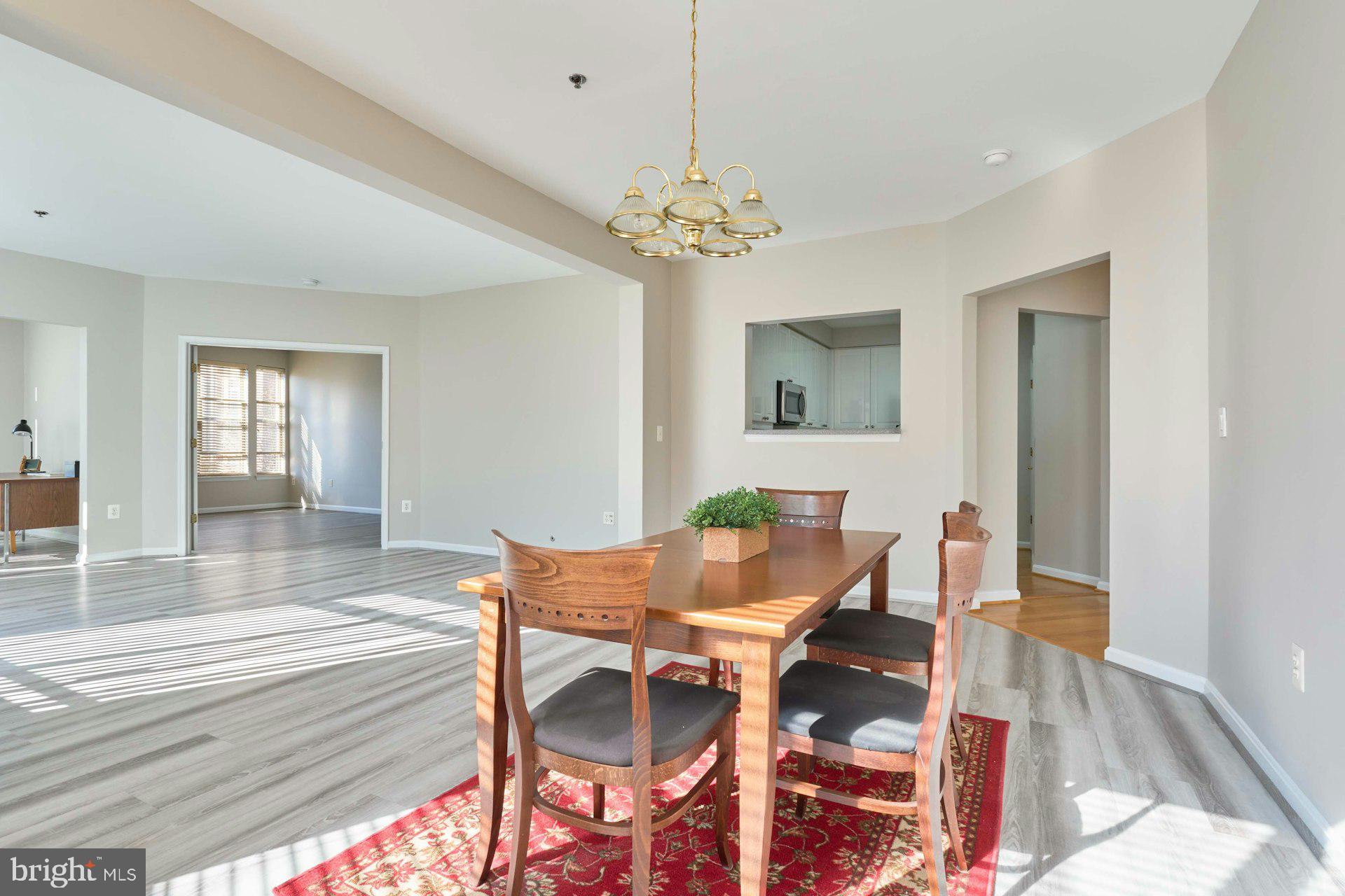 1851 Stratford Park Place, Unit 212 Reston, VA 20190 - Photo 7 of 40 a view of a dining room with furniture and chandelier