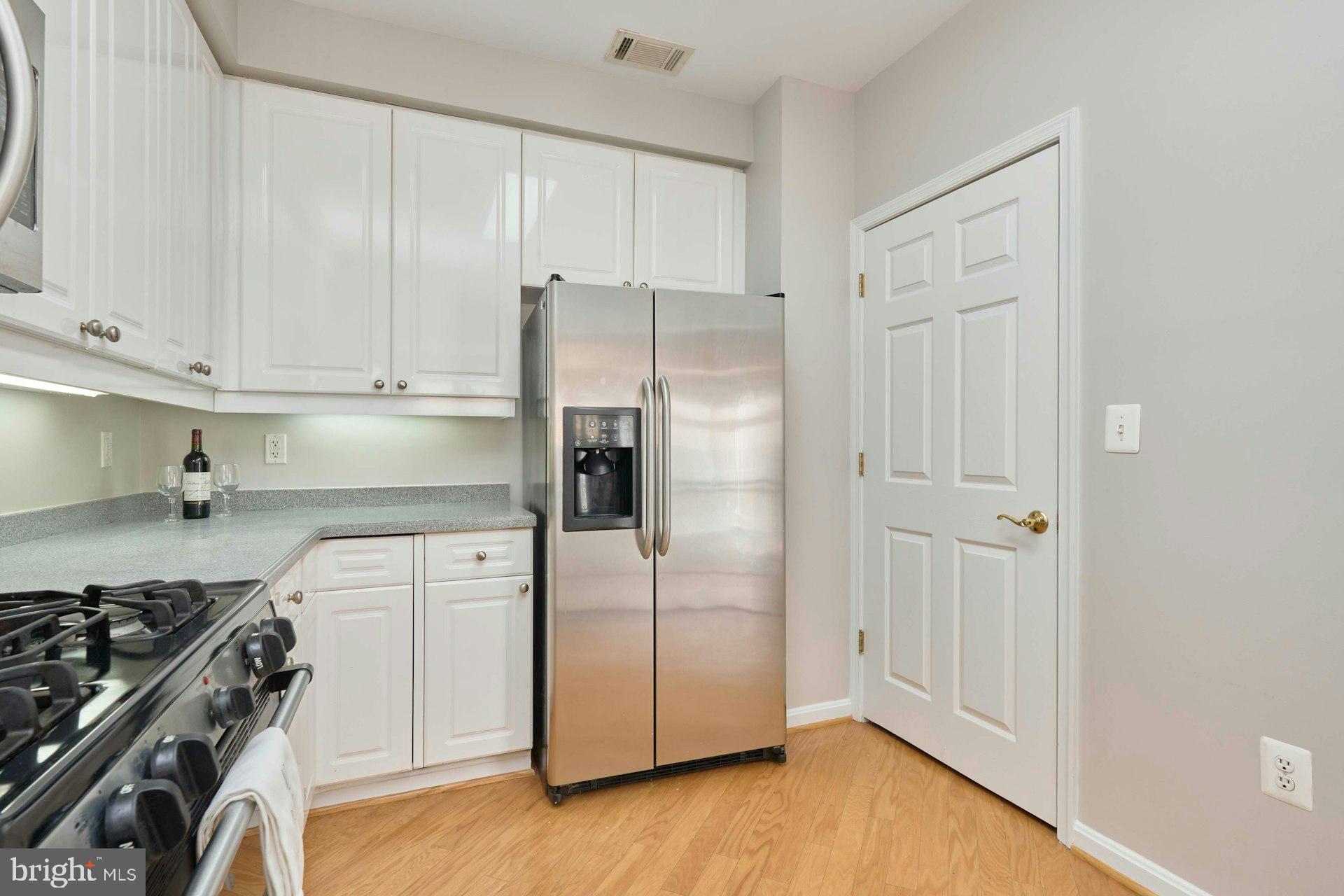 1851 Stratford Park Place, Unit 212 Reston, VA 20190 - Photo 9 of 40 a kitchen with a refrigerator and a stove top oven