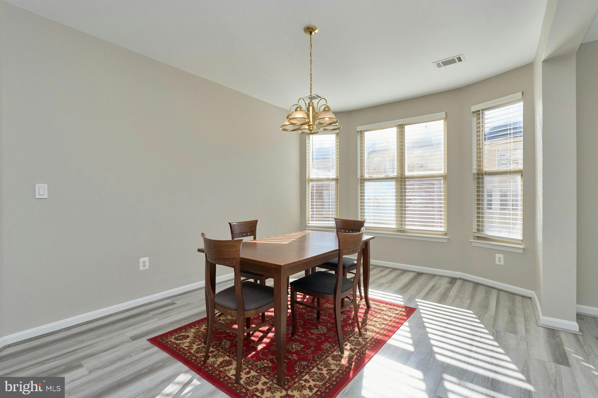 1851 Stratford Park Place, Unit 212 Reston, VA 20190 - Photo 10 of 39 a view of a dining room with furniture window and wooden floor