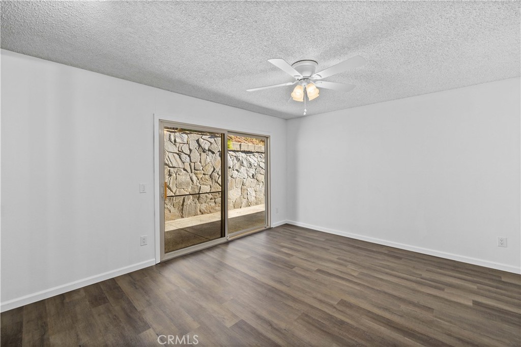 26562 Cardwick Court Newhall, CA 91321 - Photo 14 of 34 an empty room with wooden floor fan and windows