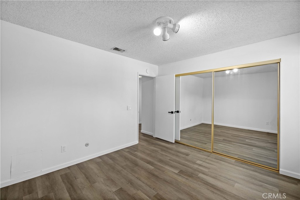26562 Cardwick Court Newhall, CA 91321 - Photo 19 of 34 an empty room with wooden floor chandelier fan and windows