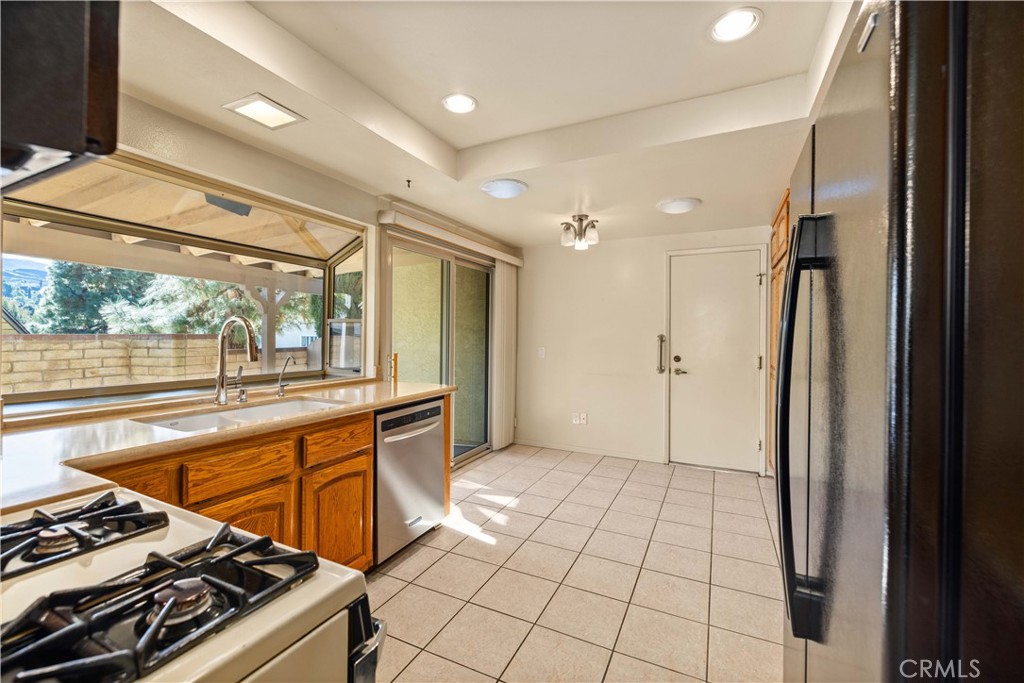 26562 Cardwick Court Newhall, CA 91321 - Photo 8 of 34 a kitchen with stainless steel appliances granite countertop a refrigerator and a sink