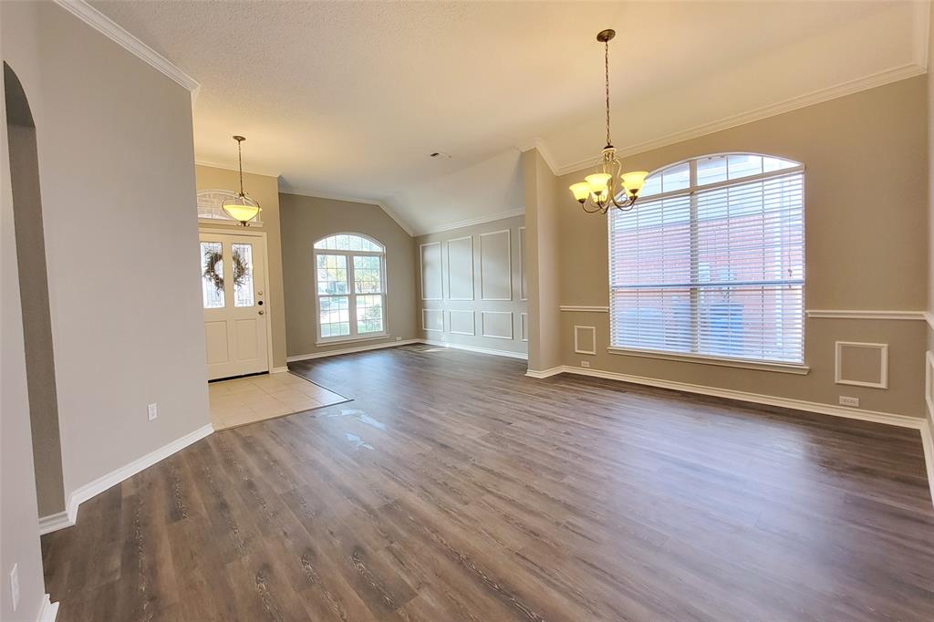 1604 Knoll Ridge Circle Corinth, TX 76210 - Photo 11 of 37 Expansive interior featuring wood-finish flooring, vaulted ceilings, and a decorative chandelier