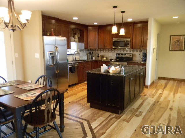 1712 North 3/10 Road Fruita, CO 81521 - Photo 7 of 34 a kitchen with granite countertop a table chairs microwave and refrigerator