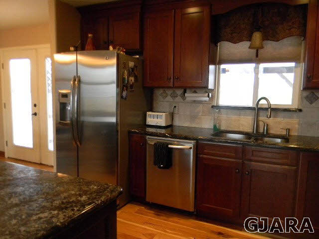1712 North 3/10 Road Fruita, CO 81521 - Photo 9 of 34 a kitchen with granite countertop a refrigerator and a sink