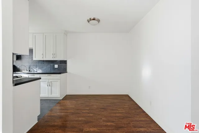 a kitchen with granite countertop white cabinets and white appliances