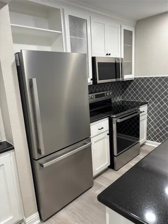 a kitchen with microwave stove and a sink