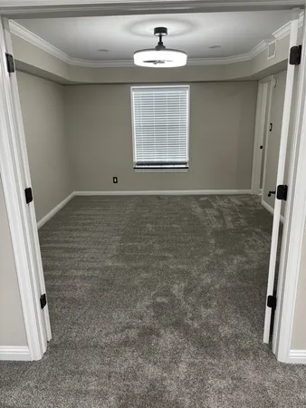 a view of a hallway with wooden floor and a bathroom