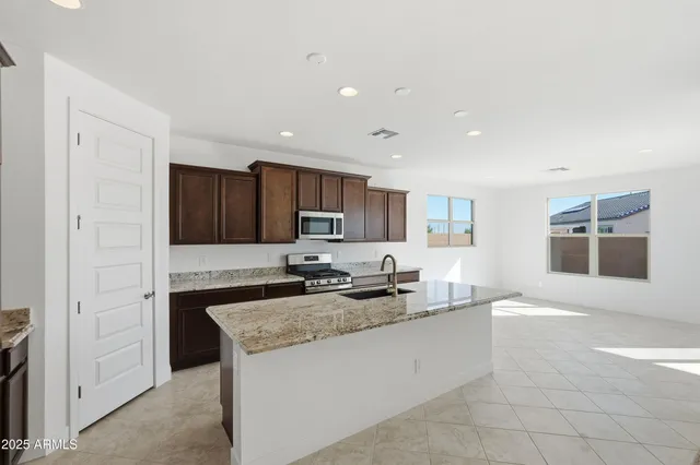 a kitchen with granite countertop a sink and cabinets