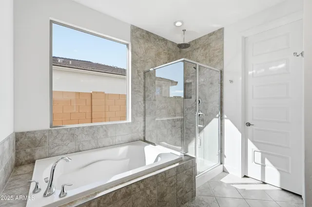 a bathroom with a tub a sink and a large window