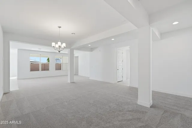 en empty room with windows and chandelier