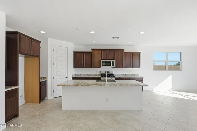a large kitchen with stainless steel appliances kitchen island a stove a refrigerator a sink and a stove