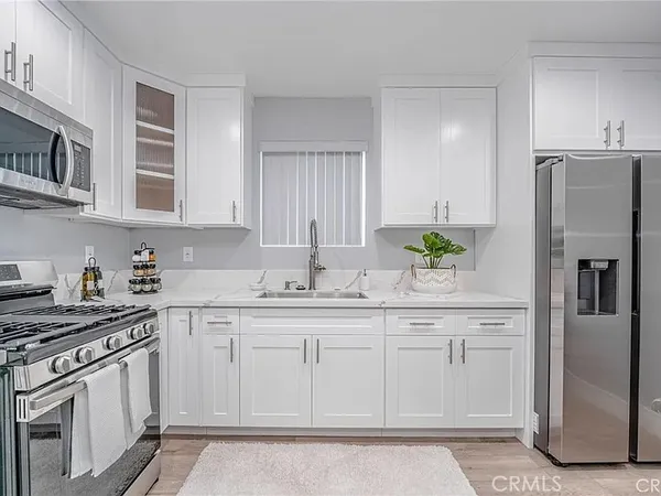 a kitchen with stainless steel appliances granite countertop a refrigerator sink and stove