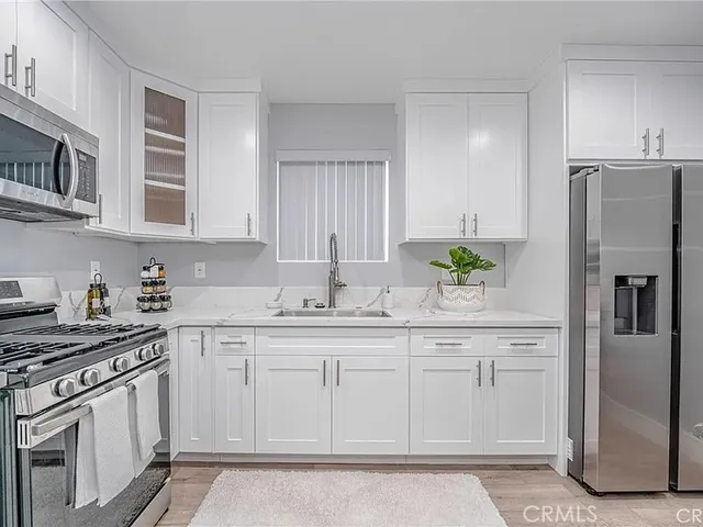 a kitchen with stainless steel appliances granite countertop a refrigerator sink and stove