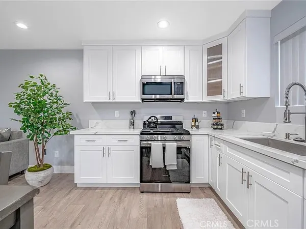 a kitchen with a white stove top oven and cabinets