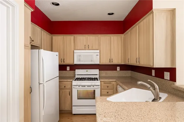 a kitchen with a refrigerator a stove and white cabinets