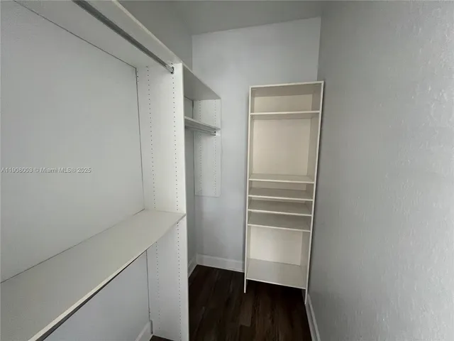 a view of walk in closet with empty racks