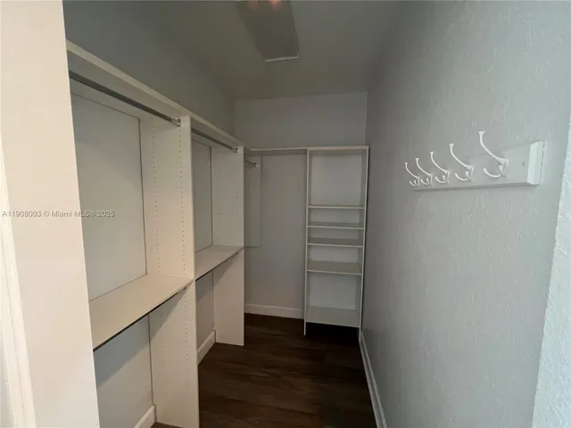 a view of walk in closet with empty racks