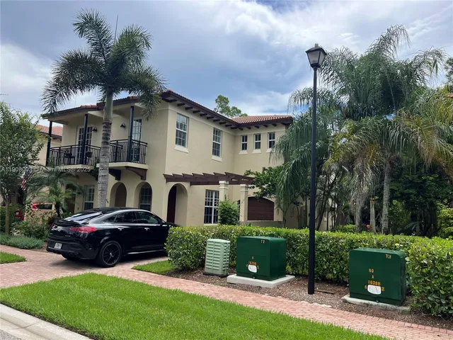 a front view of a house with a garden and trees