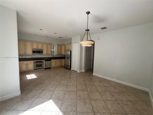 a view of a kitchen with a stove cabinets and a floor to ceiling window