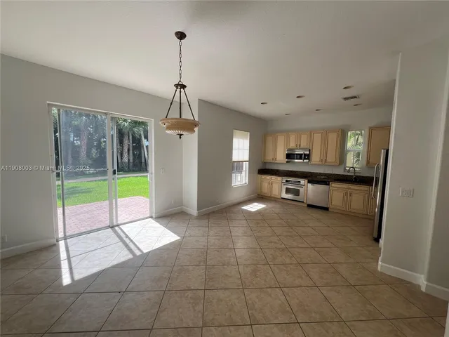 a open kitchen with stainless steel appliances granite countertop a refrigerator and a stove top oven