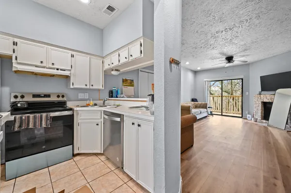 a kitchen with cabinets and wooden floor